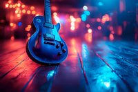 Electric guitar on wooden floor with vibrant neon lights and bokeh effects in red and blue colors creating atmospheric music venue ambiance.
