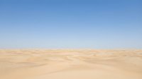 Vast desert landscape with rolling sand dunes under clear blue sky, suitable for travel, nature, and background design projects.