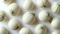 Fresh ripe cantaloupe melons arranged in rows on white background, top view. Organic whole fruits with textured skin pattern create minimalist food composition.
