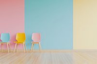 Colorful pastel chairs against pink, blue, and yellow wall sections in minimalist interior with wooden floor, creating bright modern waiting area.