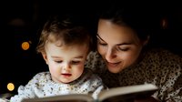Young mother reading bedtime story to toddler son in cozy evening light with warm bokeh background creating intimate family bonding moment at home.