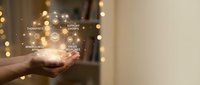 Hand holding glowing digital network icons representing social media connectivity and online communication in warm bokeh lighting atmosphere.