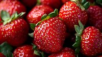 Fresh ripe strawberries with bright red color and green leaves close up macro shot showing natural texture and juicy details for food photography.