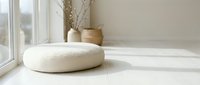 Round white boucle floor cushion in a bright minimalist room with natural light, vases, and neutral tones for home decor inspiration.