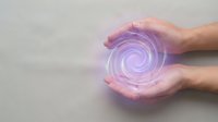 Hands cupping glowing purple energy spiral for healing, meditation, wellness and spiritual practices with copy space.