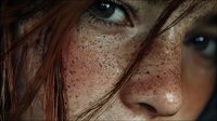 Close-up portrait of young Caucasian woman with freckles and blue eyes. Natural beauty concept with detailed skin texture and auburn hair strands.