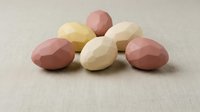 Colorful chocolate Easter eggs in pastel pink, yellow and white arranged on neutral beige background for spring holiday celebration and confectionery design.