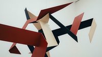 Abstract geometric composition with intersecting angular shapes in burgundy, black, pink and beige creating dynamic movement on neutral background.