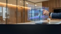 Businessman in dark suit interacting with holographic financial data display showing charts and graphs in modern office environment with wooden interior design.