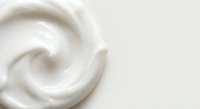 Creamy white swirl texture with smooth flowing curves creating elegant spiral pattern for skincare cosmetics and beauty product backgrounds.