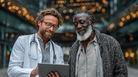 Two diverse male doctors smiling while reviewing patient data on tablet in modern hospital lobby with warm bokeh lighting background for healthcare teamwork.