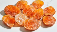 Orange Himalayan salt lamps arranged on white marble surface, glowing with warm amber light, creating peaceful atmosphere for meditation and wellness spaces.