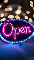 Glowing pink neon open sign with blue LED border against dark background with soft bokeh lights creates welcoming business atmosphere.