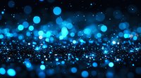 Glowing blue bokeh lights scattered on dark background create magical atmosphere. Abstract defocused particles with blur effect for festive designs.