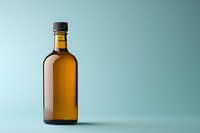 Glass brown bottle with liquid on mint green background, minimalist composition with dramatic side lighting and soft shadow for product photography.