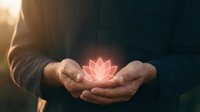 Person with weathered hands holding glowing pink lotus flower against dark background with warm sunlight, symbolizing spirituality, healing, meditation, wellness and inner peace.