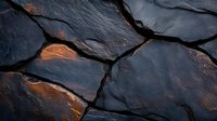 Dark fractured stone surface with orange and copper metallic highlights glowing through deep cracks and fissures against dramatic black background. Suitable for abstract backgrounds.