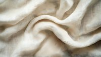 Soft beige linen fabric with gentle folds and natural texture creates flowing waves and curves, showcasing organic movement and light textile details.