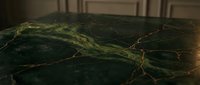 Dark green marble surface with golden veins and natural stone texture for luxury interior design and architectural applications.