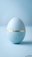 Blue speckled Easter egg with gold band decoration on soft blue background for spring holiday celebrations and festive designs.