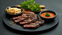 Juicy grilled beef steak sliced on black plate with dipping sauces and fresh herbs, gourmet restaurant meal presentation.