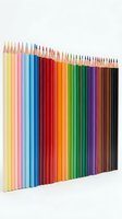 Assorted colored pencils arranged in a gradient spectrum from yellow through pink, blue, red, orange, green, purple to black on white background for art and design projects.