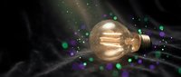 Vintage Edison bulb glowing with colorful bokeh lights and energy rays on dark background. Creative lighting concept for innovation and bright ideas.