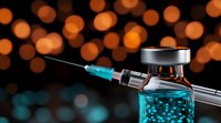 Medical vial with blue liquid and syringe against blurred warm bokeh background, dramatic lighting creates contrast between turquoise medicine and orange lights.