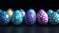 Decorated Easter eggs in vibrant blue and purple colors with delicate floral and polka dot patterns arranged in row on dark background. For holiday designs.