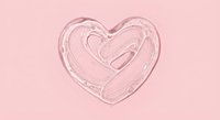 Pink heart shape drawn with glossy lip gloss on soft pink background for beauty cosmetics and Valentine's Day romantic designs.