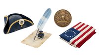 Vintage military memorabilia collection featuring navy bicorne hat, feather quill pen, eagle medallion and American flag fabric on isolated white background for design projects.