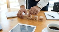 Professional businessman arranging wooden blocks with star rating symbols on office desk, customer satisfaction and quality service evaluation concept.