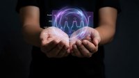 Male hands holding glowing digital sphere with purple neon waveform and data visualization, representing technology, innovation, and digital transformation for business and healthcare concepts.