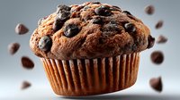 Freshly baked chocolate chip muffin with rich cocoa flavor and scattered coffee beans on clean background for bakery and cafe marketing materials.