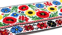 Traditional Ukrainian embroidery pattern with colorful floral motifs including poppies, cornflowers and folk ornaments on white fabric for cultural design projects.