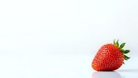 Fresh ripe strawberry with green leaves on clean white background, isolated fruit for healthy eating and organic food concepts.