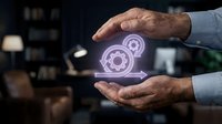 Businessman holding glowing gear icons between hands, representing technology, innovation, and digital transformation in modern business operations and workflow management.