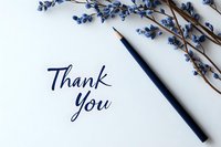Handwritten thank you note with blue pencil and decorative dried blue berries branch on white background, elegant minimalist composition for greeting cards.