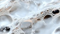 Abstract white and beige liquid surface with bubbles and foam creating delicate lace-like patterns and textures. Macro photography reveals intricate details.