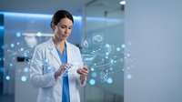 Female doctor using digital tablet with holographic medical network interface in modern healthcare facility for telemedicine and smart hospital technology.