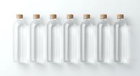 Seven empty glass bottles with cork stoppers arranged in row on white background for packaging design and product mockup.