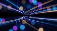 Dynamic light trails converging into central vortex with colorful bokeh effects on dark background for motion graphics and digital art projects.