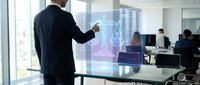 Professional businessman using holographic technology display in modern office environment with colleagues working in background.