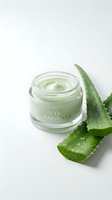 Natural aloe vera skincare cream jar with fresh plant leaves on white background for beauty and wellness product photography.
