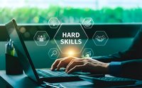 Professional businessman typing on laptop with hard skills concept overlay featuring hexagonal icons representing technical competencies and expertise development.