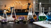 Modern chemistry laboratory setup with colorful solutions in glass flasks and beakers alongside mineral specimens for scientific research and education.