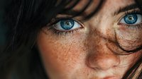 Close-up portrait of young Caucasian woman with striking blue eyes and natural freckles. Authentic beauty concept for skincare and cosmetics campaigns.