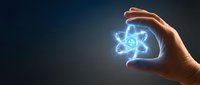 Hand holding glowing atom symbol with blue energy light against dark background. Concept for science, physics, nuclear energy, technology, and research applications.