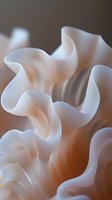 Ethereal white flowing fabric creates gentle waves and curves against soft peach background, showcasing delicate folds and graceful movement in macro photography.