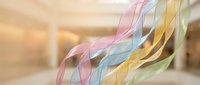 Colorful flowing ribbons in pastel pink blue yellow green dancing through bright modern interior space creating elegant movement and soft lighting effects.